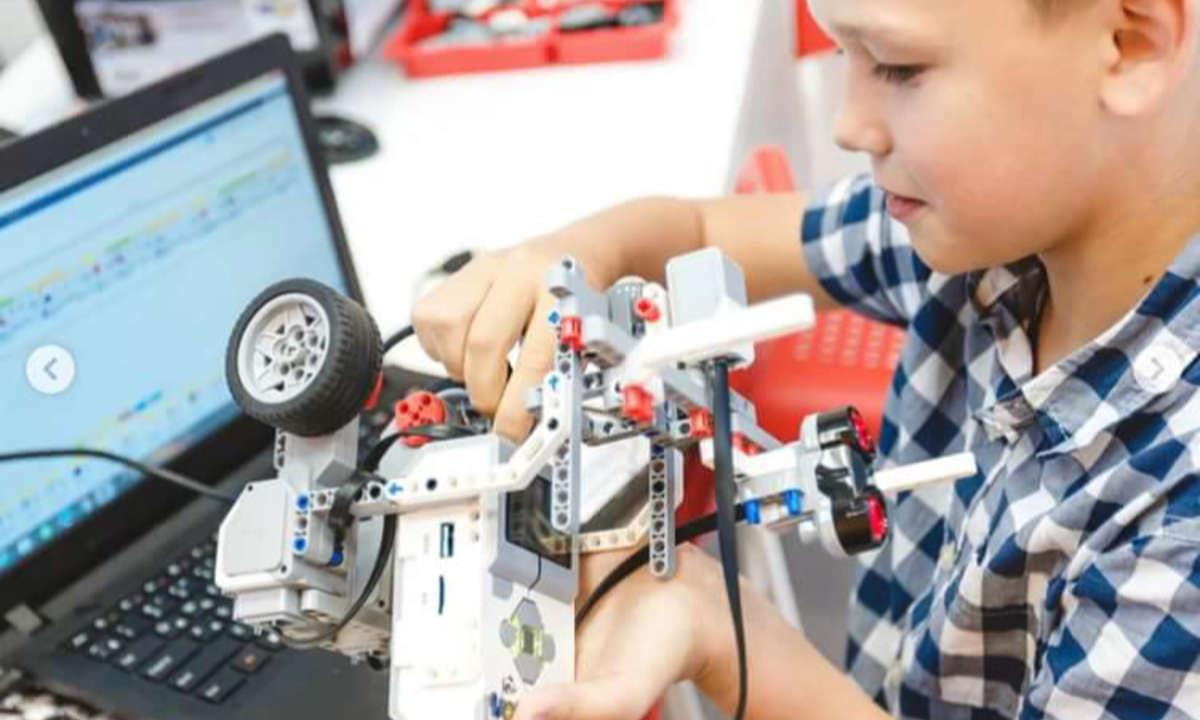 Ребенок собирает робота в кружке робототехники